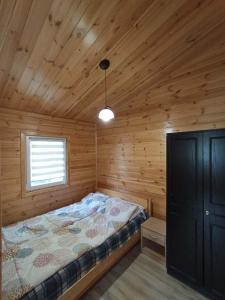 a bedroom with a bed in a wooden cabin at Domek Leszek in Mikołajki