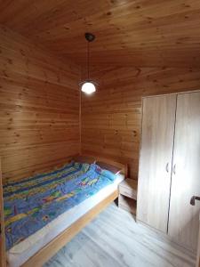 a bedroom with a bed in a wooden cabin at Domek Leszek in Mikołajki