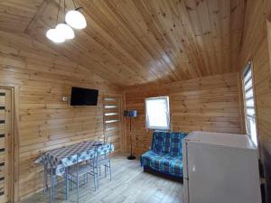 a room with a couch and a table and a tv at Domek Leszek in Mikołajki