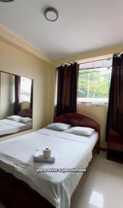 a bedroom with a bed and a large mirror at Hostal La Gata in Tingo María