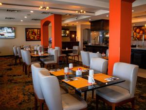 ein Restaurant mit Tischen und Stühlen und einer Küche in der Unterkunft Hotel Calafia in Mexicali