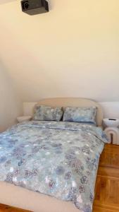 a bed with a blue comforter and two pillows at Your home in Gohrisch in Kurort Gohrisch
