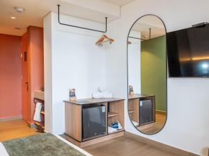 a living room with a tv and a mirror at Hunters Hotel Medellin in Medellín +62 photos