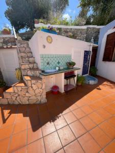 a patio with a table and a stone wall at La Vite in Ponza