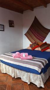a bed with pink towels on it in a room at Hostal Open House in San Pedro de Atacama