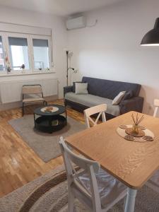 a living room with a table and a couch at Apartman 028 in Smederevska Palanka +7 photos