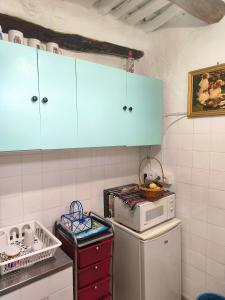a kitchen with blue cabinets and a white refrigerator at Casa MANES in Pitres +11 photos