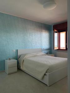 a bedroom with a bed and a blue wall at La casa di John in Guglionesi