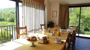 a dining room table with a view of a balcony at Chambre d'Hôtes La Bourdasse in Loubens