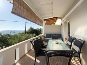 a patio with a table and chairs on a balcony at Blue Residences in Paralia Vrachou