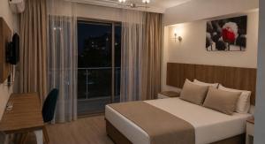 a hotel room with a bed and a large window at Vel-Mer Lefke in Ayios Nikolaos