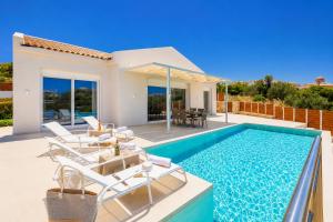 a villa with a swimming pool and a house at Casa di Pietra in Lakíthra