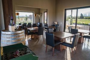 a dining room with tables and chairs and a wine cellar at Atamisque Wine Lodge - Valle de Uco in San José