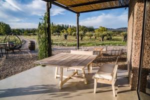 a table and chairs on a patio with a view of a field at Atamisque Wine Lodge - Valle de Uco in San José