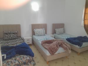 two beds in a room with blue sheets on them at Taguermess Tag 6 in Taguermess