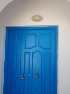 a blue door in a room with a light above it at Taguermess Tag 6 in Taguermess