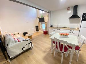 a kitchen and living room with a table and a couch at El Nidito del valle del Tietar in La Iglesuela