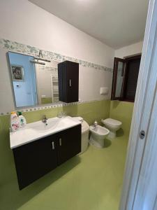 a bathroom with a sink and a toilet and a mirror at Da Lucia in Francavilla al Mare