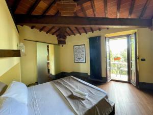 a bedroom with a bed and a large window at Dimora 45, Contemporary Apartments in a Historic Building, Valdichiana, Tuscany in Sinalunga