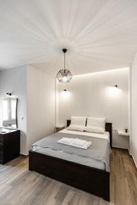 a bedroom with a large bed and a chandelier at Exclusive suite in Hersonissos