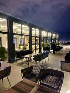 ein Gebäude mit Stühlen und Tischen auf einem Dach in der Unterkunft Platinum Hôtel Spa Abidjan Cocody in Abidjan
