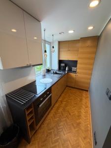 a kitchen with wooden cabinets and a black stove top oven at Old Town Apartment in Võru