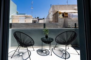 three chairs and a table on a balcony at Exclusive suite in Hersonissos