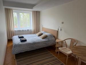 a bedroom with a bed and a table and a window at Old Town Apartment in Võru