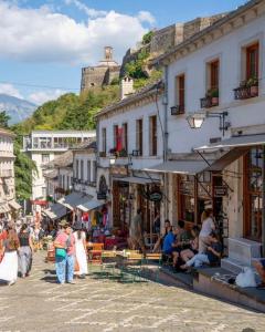 a crowd of people walking around a street with a castle in the background at Cozy City Studio in Gjirokastër
