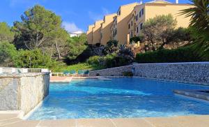 a swimming pool with blue water in a resort at Petit Paradis Apartment in Son Bou +12 photos