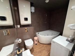 a bathroom with a tub and a toilet and a sink at Old Town Apartment in Võru