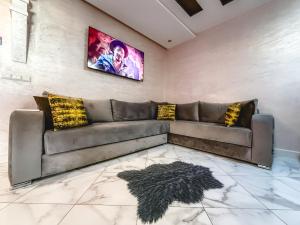 a living room with a couch and a painting on the wall at Les Jardins Anass 1 aéroport Marrakech in Marrakesh