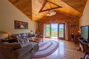 a living room with a couch and a tv at High Road Cabin in Banner Elk