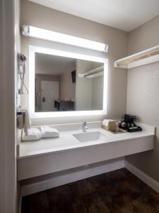 a bathroom with a sink and a large mirror at River Inn Motel in San Antonio