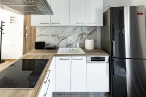 a white kitchen with a sink and a refrigerator at Exclusive suite in Hersonissos