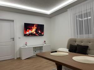 a living room with a table and a fire on the wall at Al Noor Villa Ilidža in Ilidža