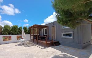 a small house with a deck and a patio at Catshouse in Carqueja