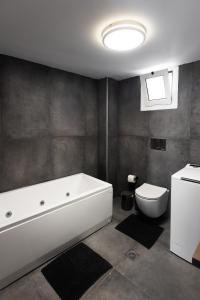 a bathroom with a white tub and a toilet at Exclusive suite in Hersonissos +15 photos