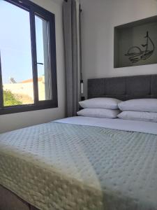 a bedroom with a large bed with a window at CONSTA Luxury House in Mantamádos