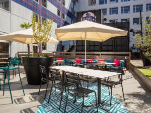 an outdoor patio with tables and chairs and umbrellas at ibis Styles Paris Bercy in Paris