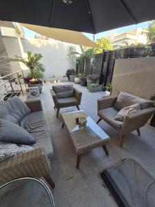 an outdoor patio with chairs and tables and an umbrella at Global Rabin apartment דירה לטווח קצר in Petaẖ Tiqwa