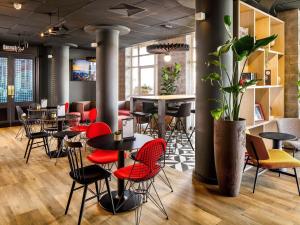 a restaurant with red chairs and tables in a room at ibis London Greenwich in London