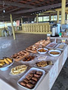 a table with many different types of food on it at Hotel Torre Forte in Careiro