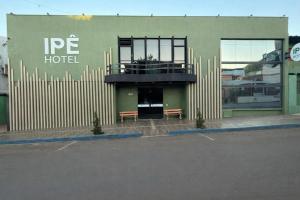 a building with two benches in a parking lot at Hotel Ipê in São Luís Gonzaga