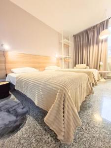a bedroom with two beds with white sheets at Eva Urban Rooms Centro Lecco in Lecco