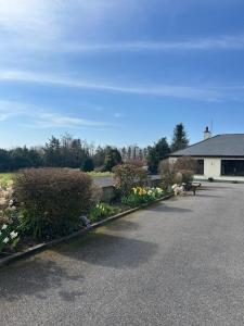 a parking lot with flowers and a building and a house at Simple Stay Foxford in Foxford