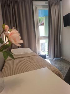a bedroom with a bed and a window with a flower at Eva Urban Rooms Centro Lecco in Lecco