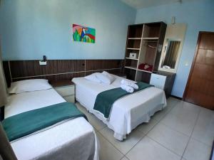 a hotel room with two beds with towels on them at Miotto Executive Hotel in Navegantes