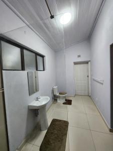 a white bathroom with a sink and a toilet at Mon Desir Estate - NR3 in Pietermaritzburg