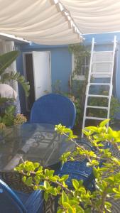 a patio with a table and a ladder and a chair at Dar Moussa Assilah in Asilah